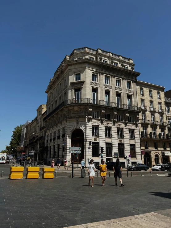 people standing outside of a building in front of a road