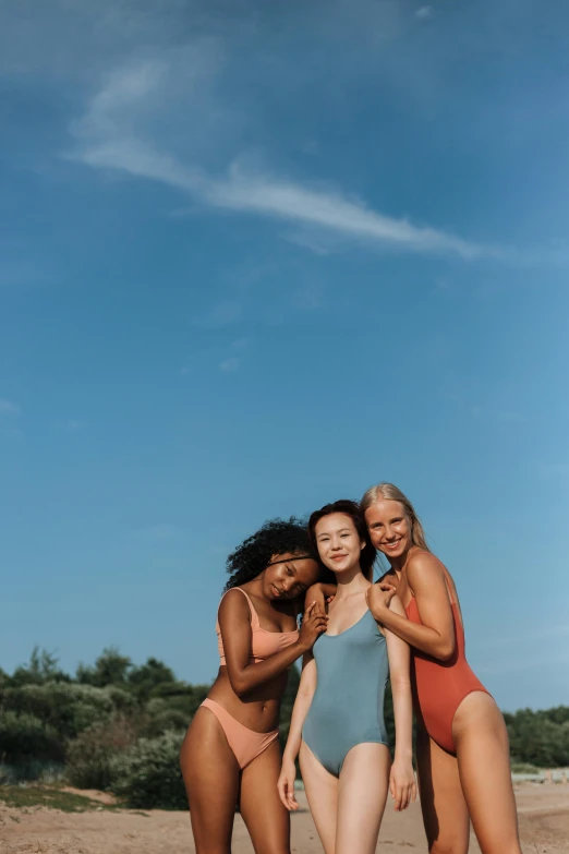 four women standing in the sand on the beach