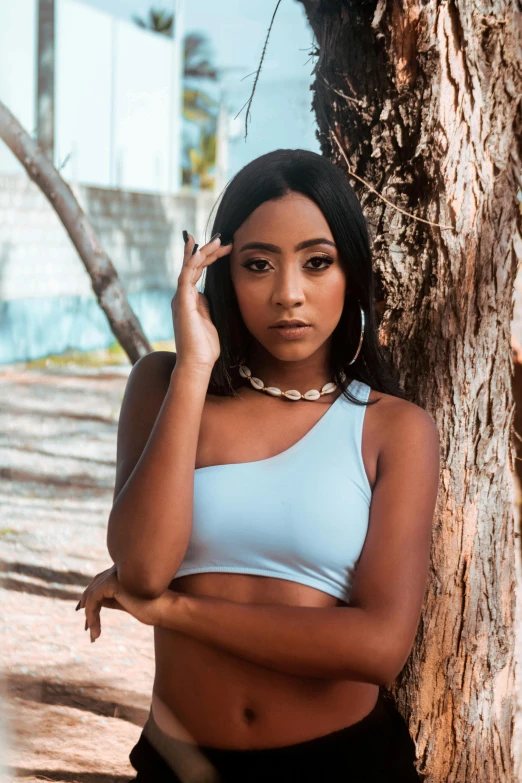 a woman in a white  top next to a tree