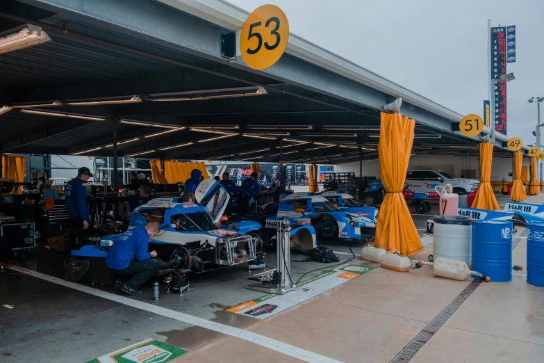 the blue race cars are parked next to each other