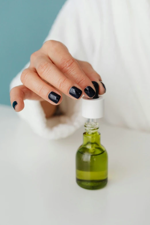 a woman wearing black polish has her finger extended