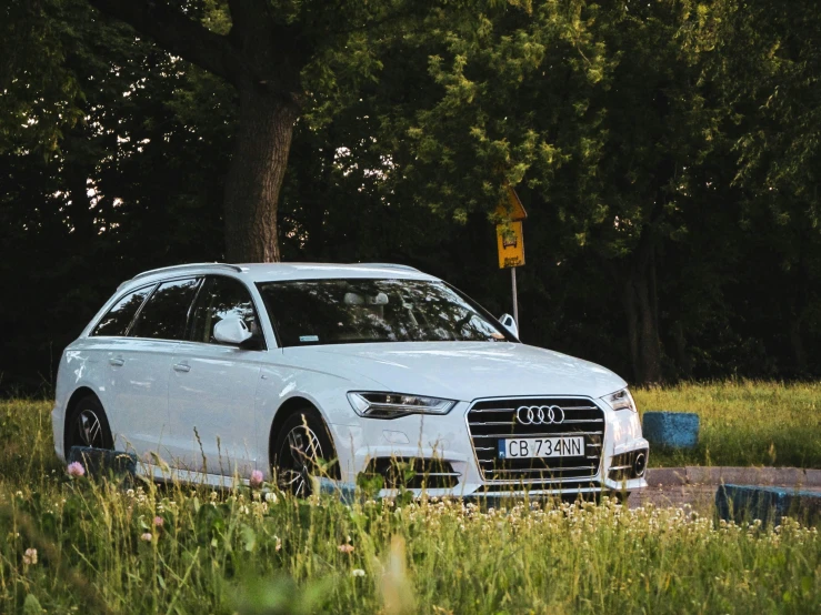 an all white car parked on the side of a road