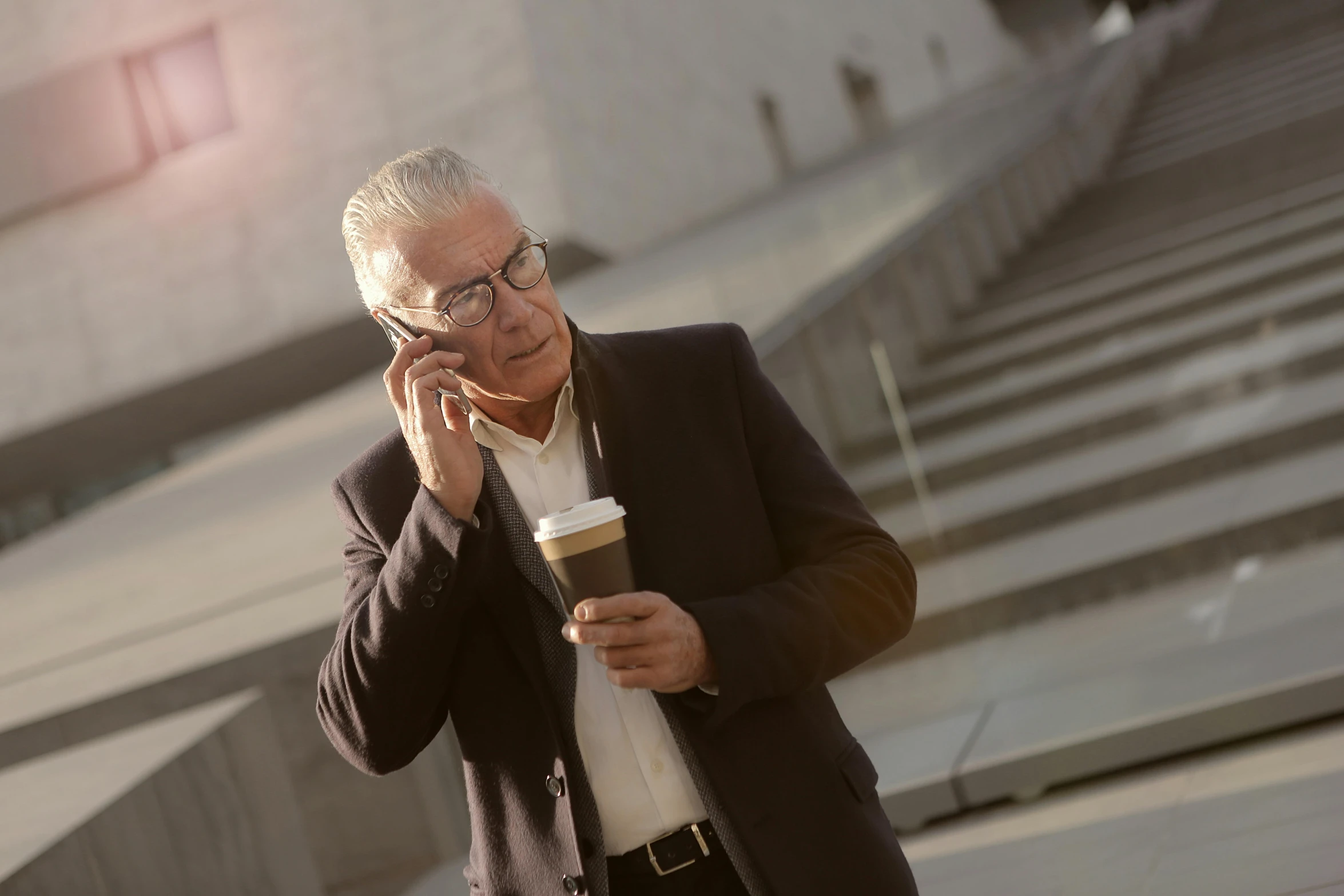 a man talking on a phone while drinking