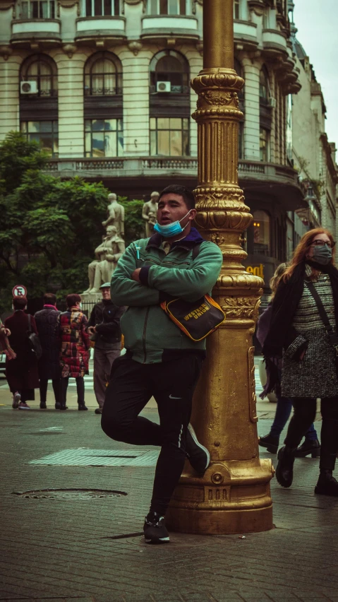 man with his eyes closed leaning on a golden pole