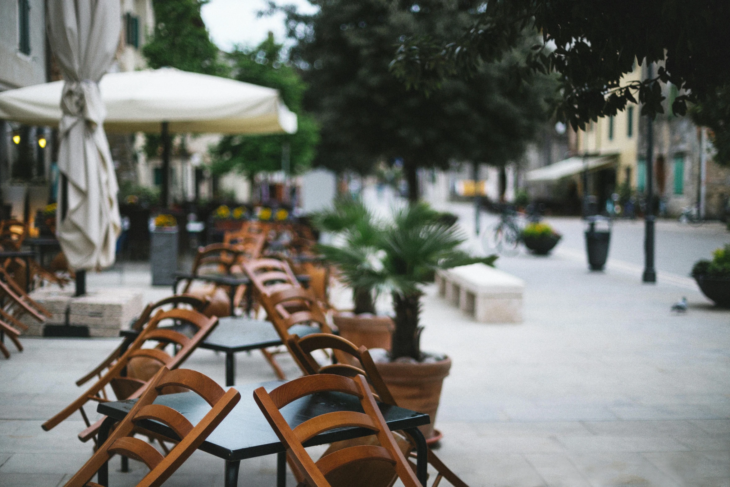 the tables and chairs are lined up outside on the street