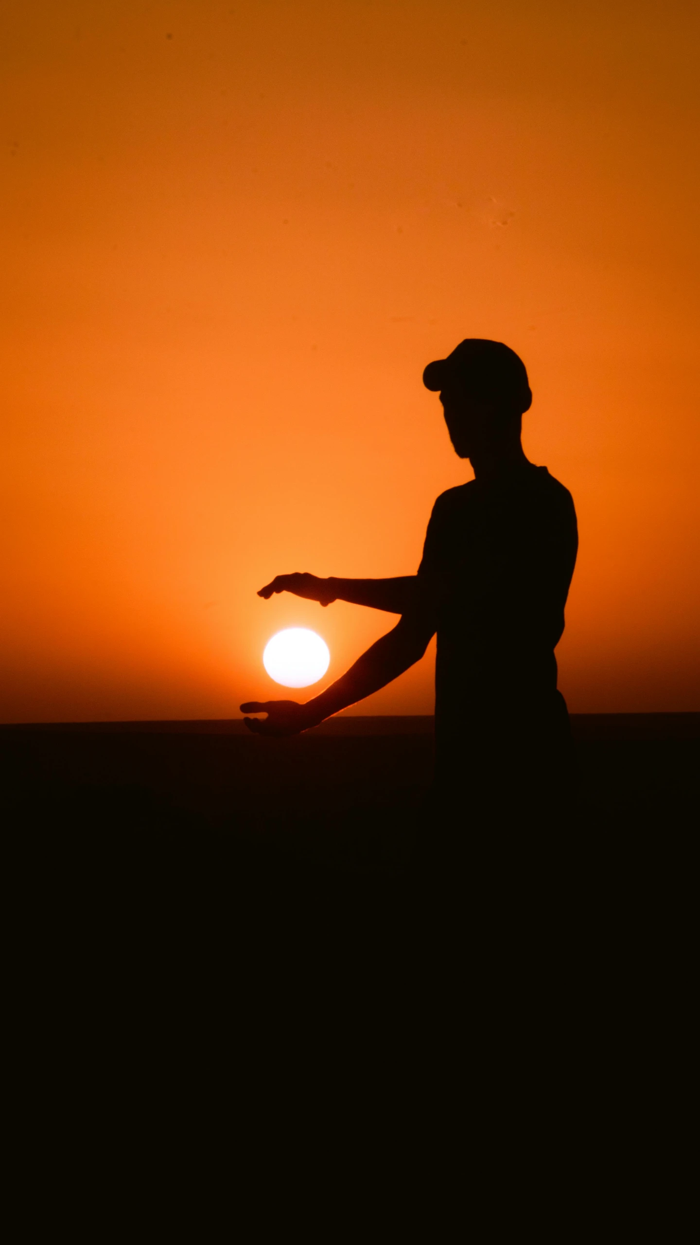 a silhouette of a person in front of a setting sun