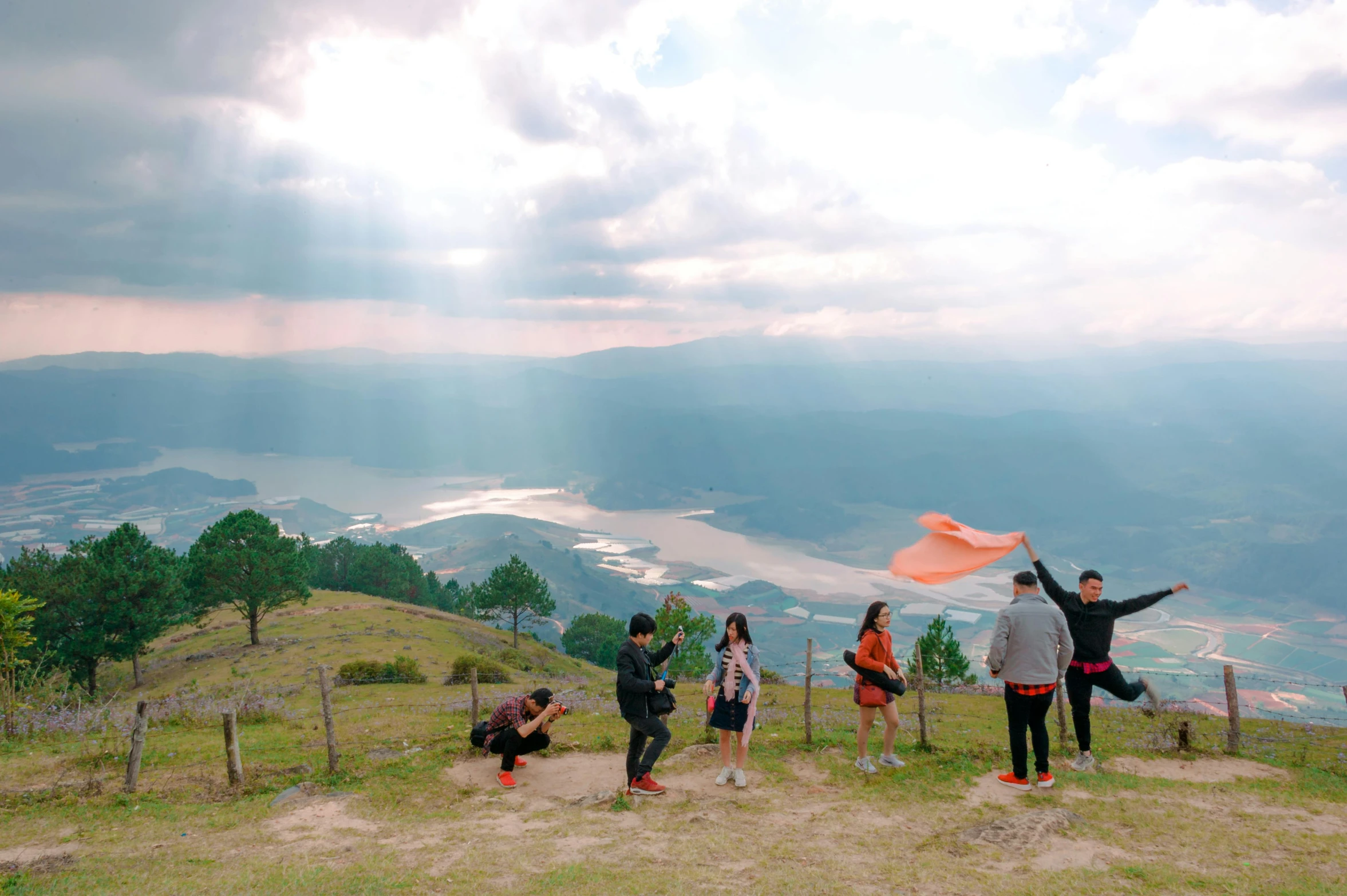 a group of people at the top of a hill looking out on the valley