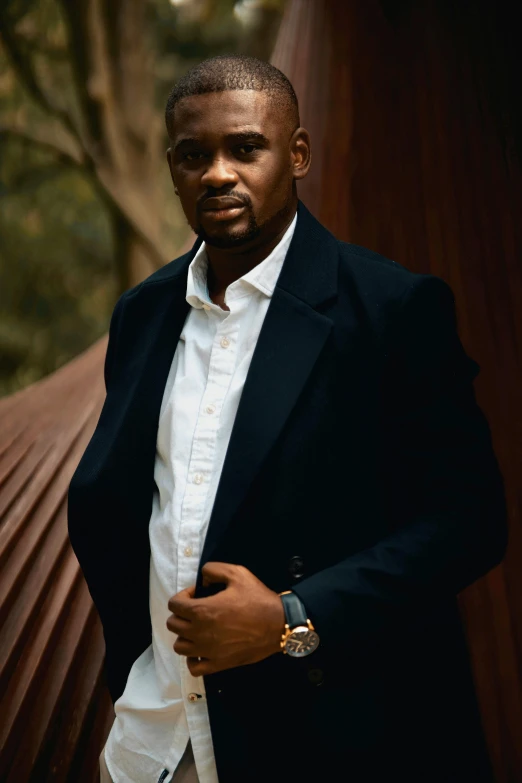 a young man in a black jacket is posing for a picture