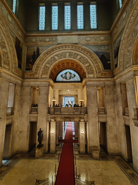 inside a stone building that has red carpet on the floor