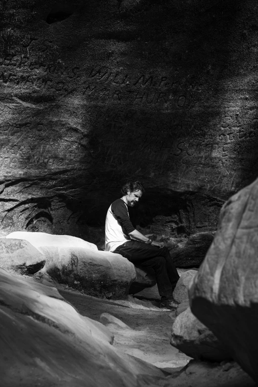 man seated near water in black and white po