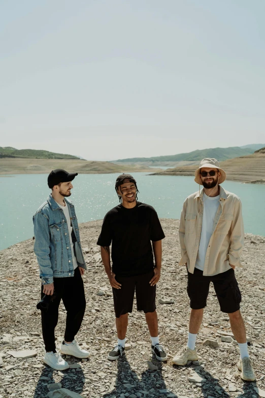 three guys posing on the beach for a po