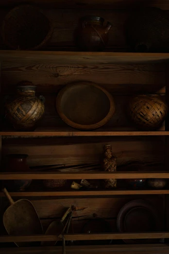 a wooden shelf with some bowls and plates on it