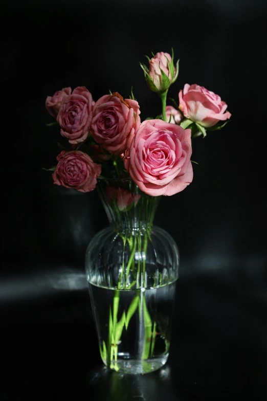 a vase with many pink roses in it