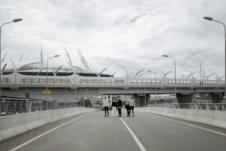 several people walk down a pedestrian bridge in the rain