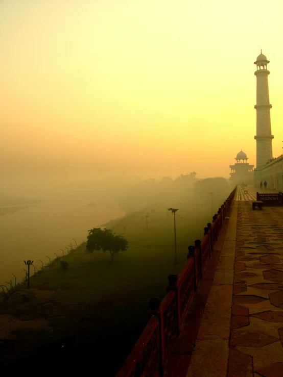 a foggy path in front of a clock tower