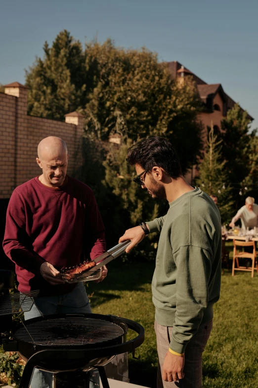 two guys are looking at soing on the grill