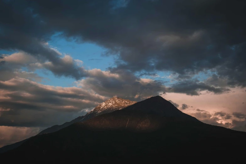 the clouds are setting on top of the mountains