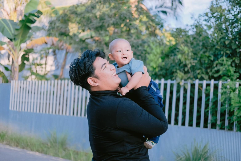 a man and baby are playing on a street