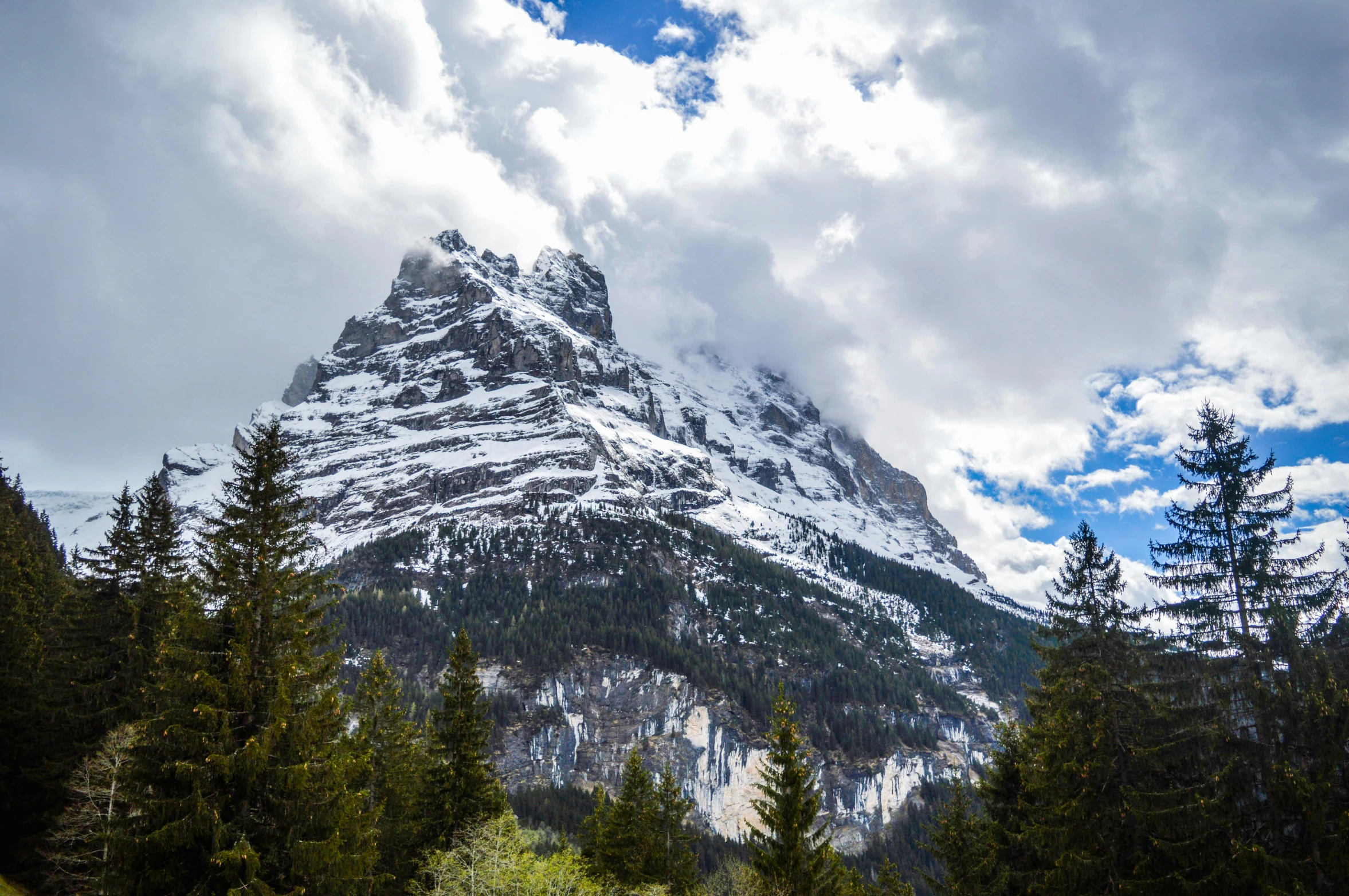 a large mountain covered in snow and clouds