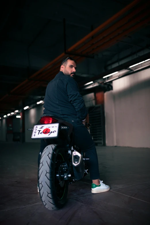 a man sitting on a bike in a parking garage