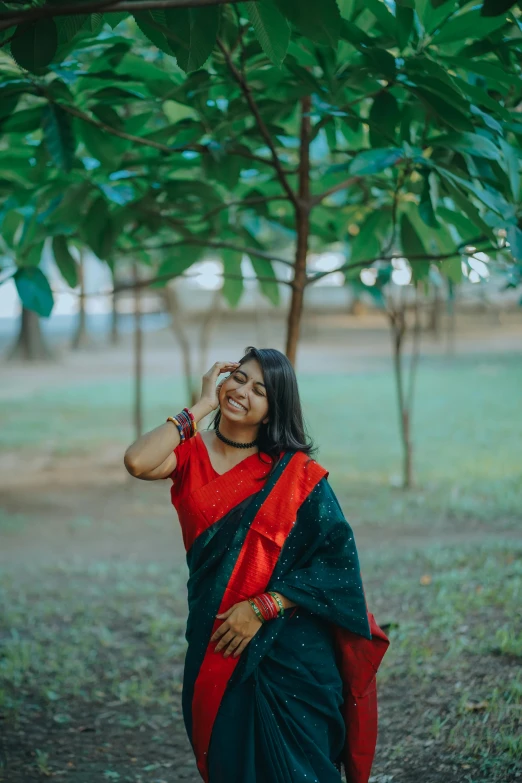 a woman in red is standing under a tree