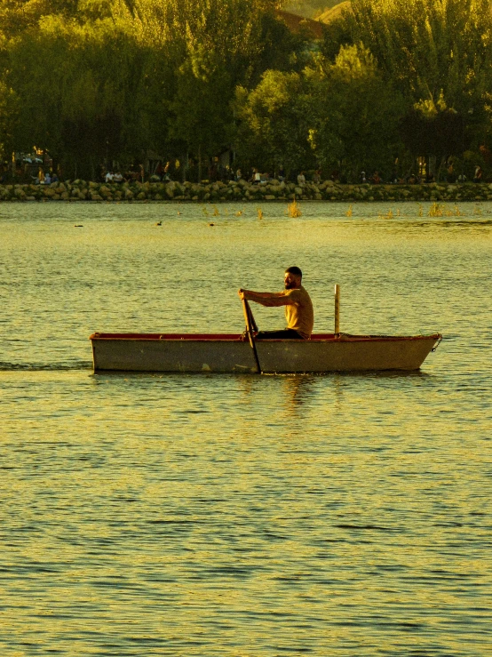 the man sits in the rowing boat on the water