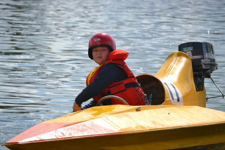 a small boy on a yellow kayak in the water