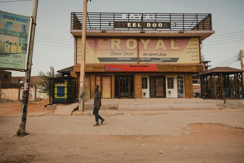 there is a man that is walking in front of a business