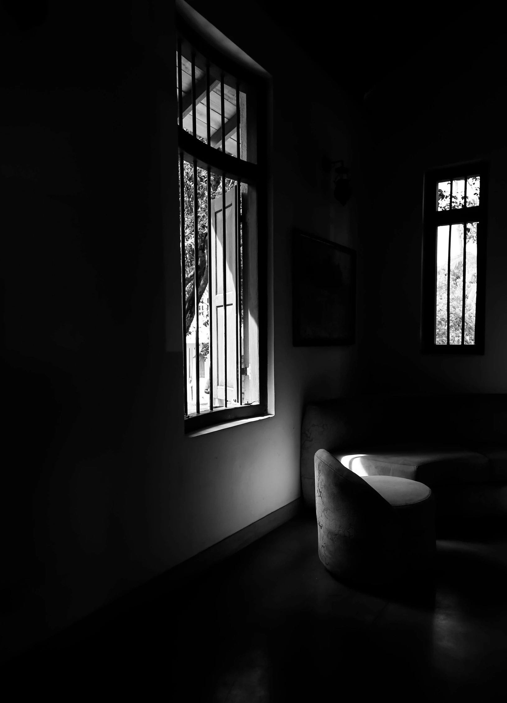 an empty room with two windows and a sofa