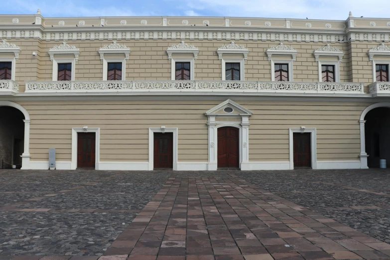 an empty plaza in front of a building with four doors
