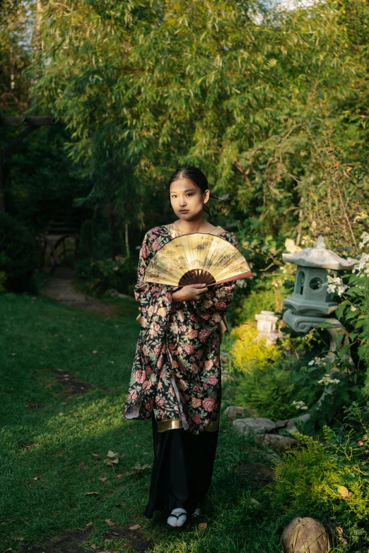 the woman is holding an oriental fan in her hands