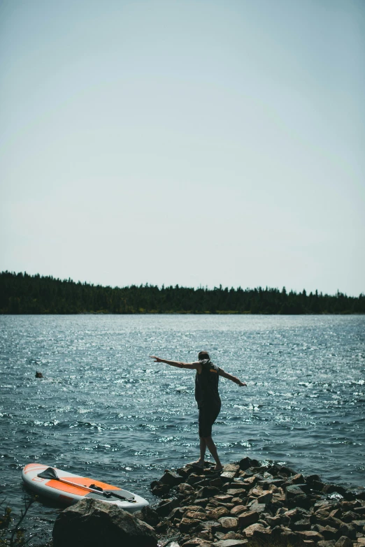 there is a man standing on the rocks in front of the water