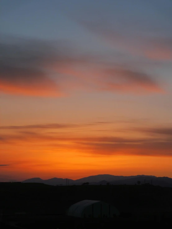 sunset with clouds and mountains in the distance