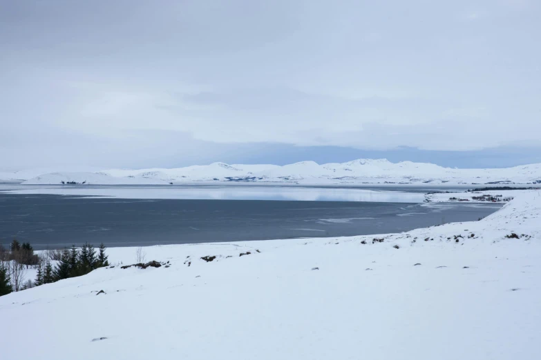 a lone snowy snowboarder going down a steep snow covered mountain