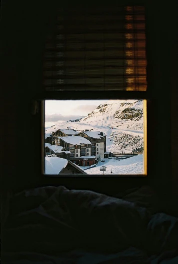 view from inside of window, of snowy mountains and houses