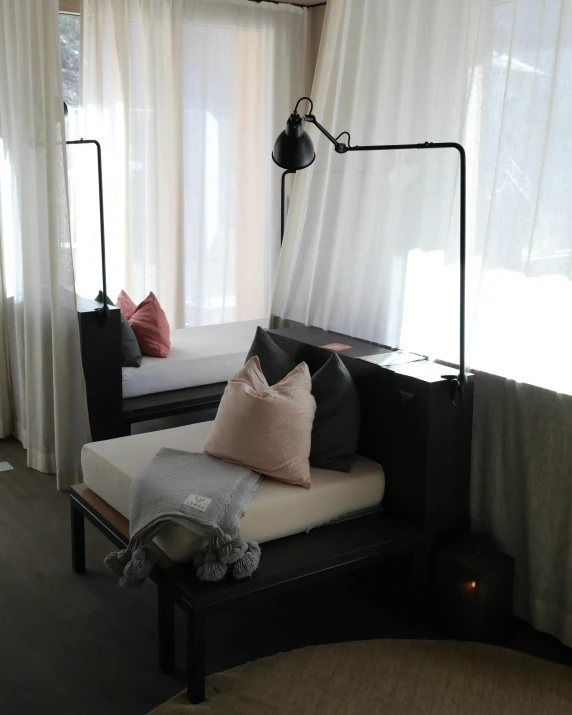 a room with curtains, a couch and a lamp