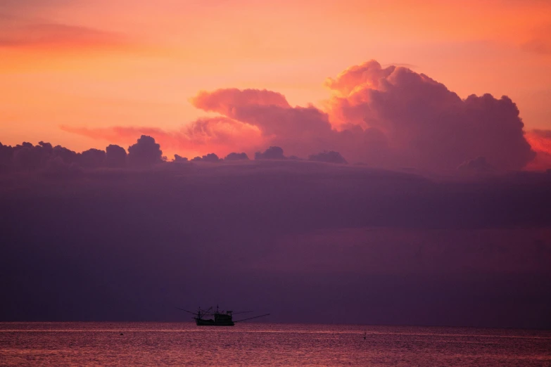 a small boat on water under cloudy skies