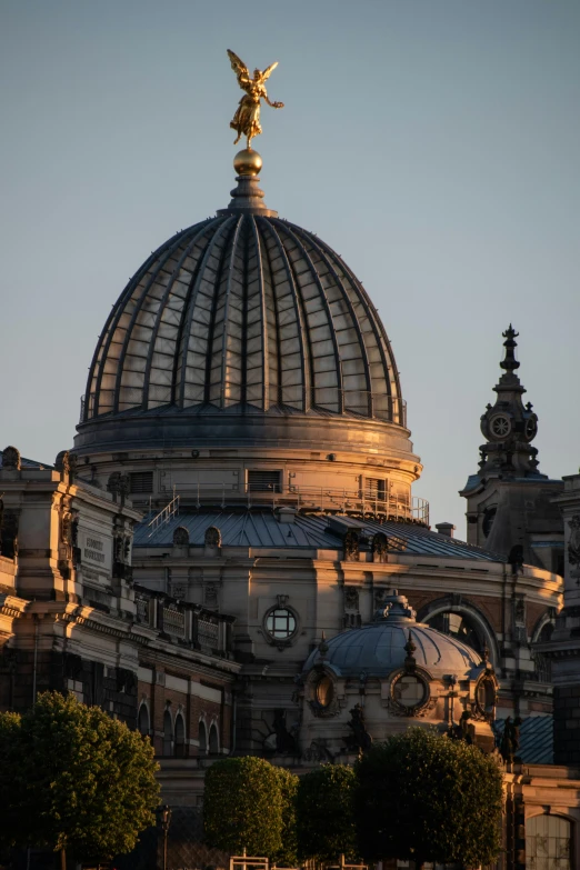 the dome on top of a building with a gold angel statue