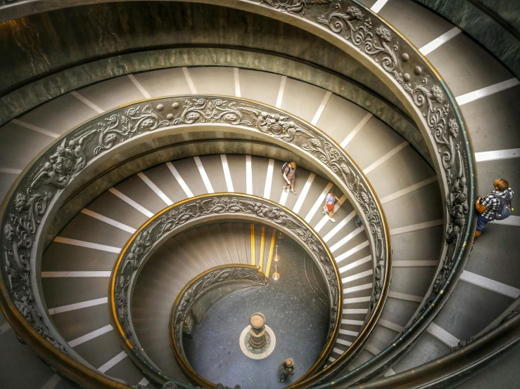 the spiral stairs of a building show people and other people