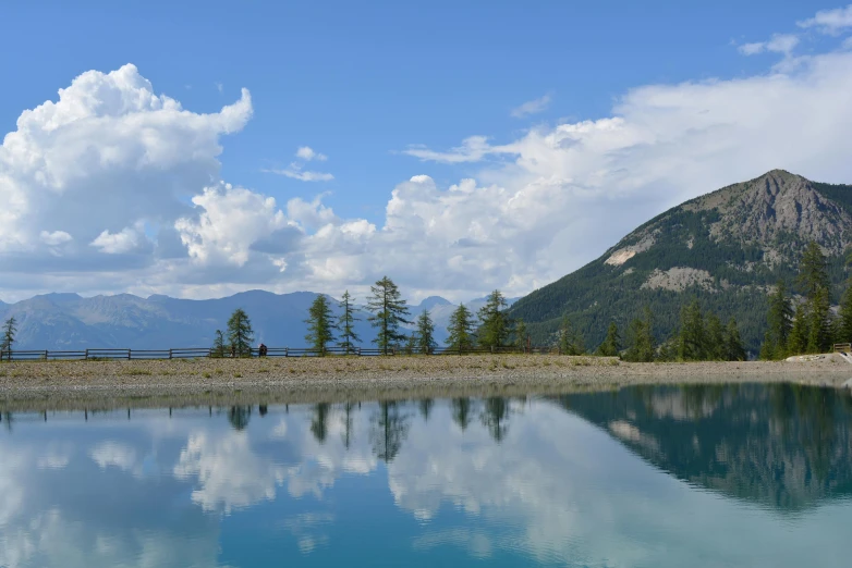 some trees and a mountain with a blue body of water