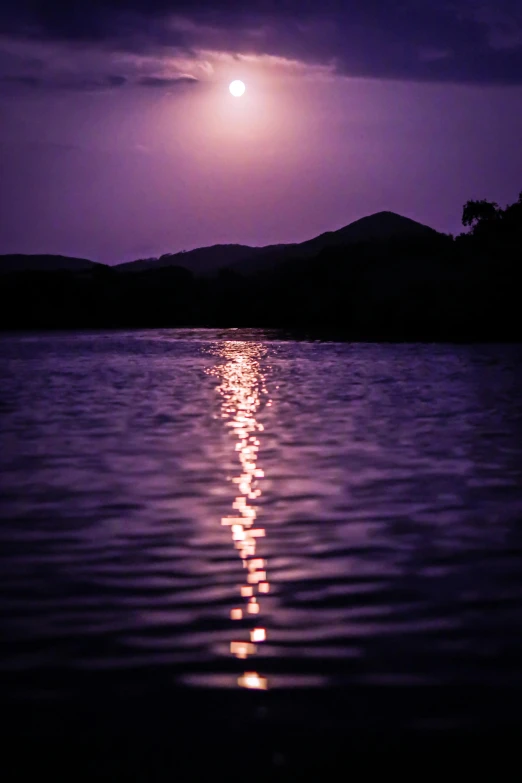 the moon shines on the water and reflects bright