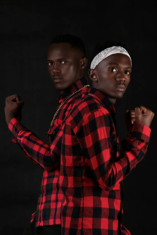 a male in red and black checkered shirt and a male with fist bumping