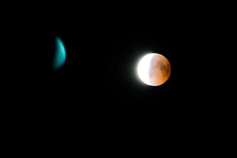 the moon partially illuminated in front of two other eclipses