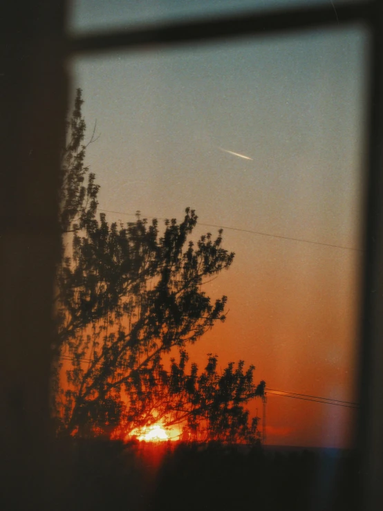 a sunset is seen through the glass of a window