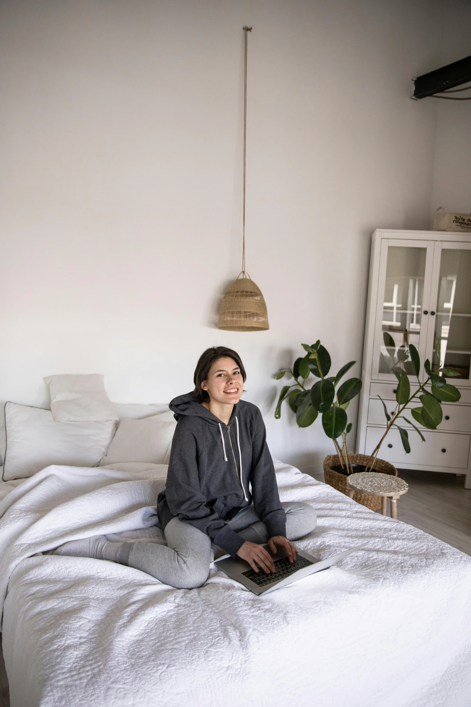 a woman is sitting on her bed and smiling