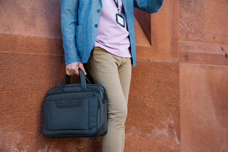 a man leaning up against the wall holding a phone