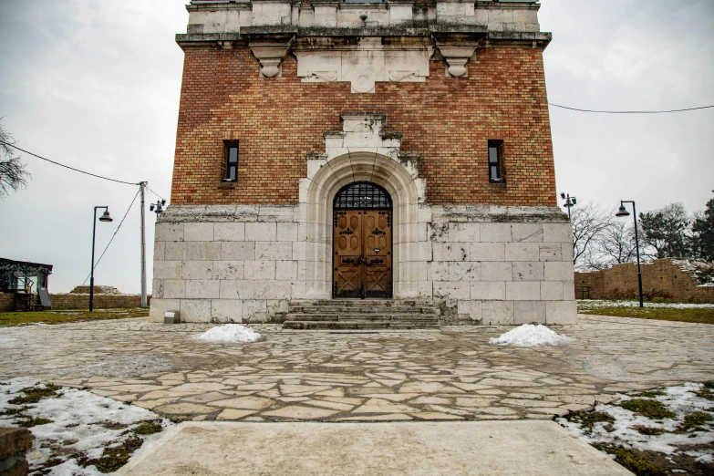 a large brick building with an arch and door