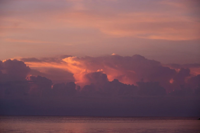 the ocean has many clouds in the distance