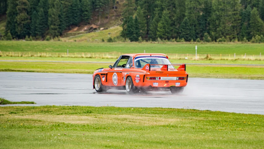 a orange race car is driving on a track