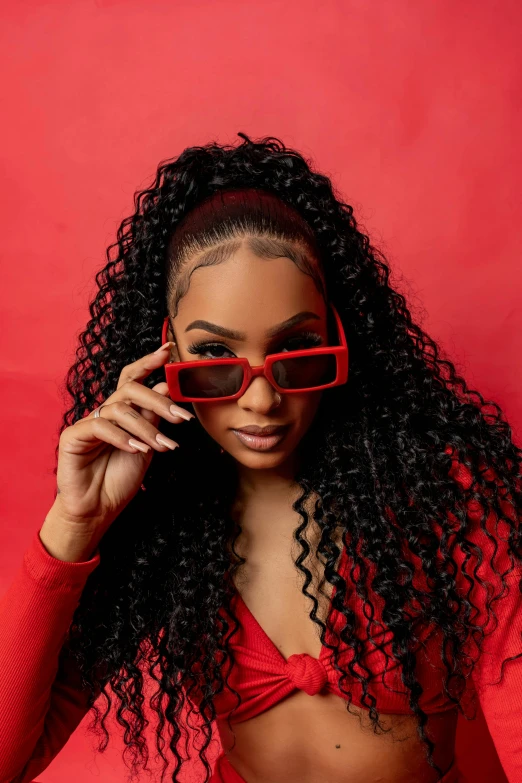 a young woman wearing red glasses in front of a red background